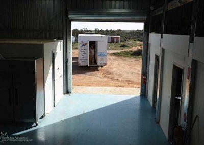 We hook up a 4WD vehicle to the van and carefully back it into Tom's shed