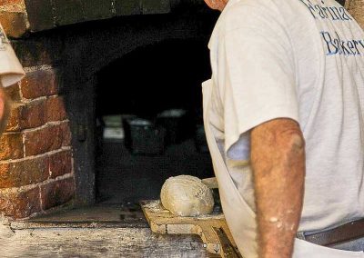 Bun being added to the oven on the wooden shovel (Peel)
