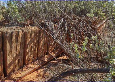 Sleepers driven into the ground on the downstream side of the raised way to help stop erosion